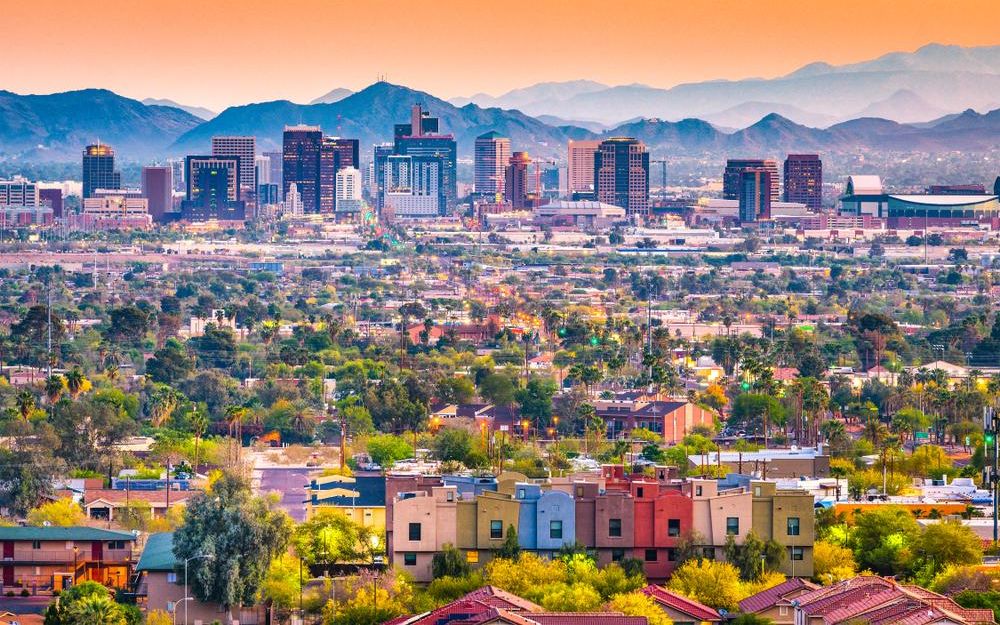 Downtown Phoenix skyline at sunset, with the mountains behind the city